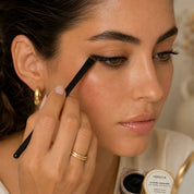 Applying Le Khôl Iconique by Hendiya with the liner brush to the eyes